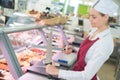 Female butcher works at supermarket