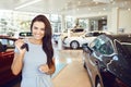 A female buyer is sitting in a new car.