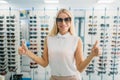 Female buyer tries on sunglasses in optics store