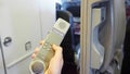 Female cabin crew pick up interphone and make emergency call in flight. Aircraft equipment.