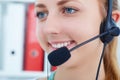 Female call center service operator at work. Portrait of pretty female helpdesk employee with headset at workplace. Royalty Free Stock Photo