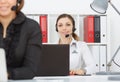 Portrait of smiling pretty female help desk employee with headset at workplace. Royalty Free Stock Photo