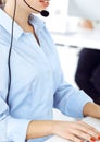 Female call operator is using computer and headset for consulting clients online, close-up. Group of diverse people Royalty Free Stock Photo