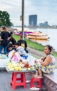 Female Cambodian food stall sellers,sit along the river wall,at Phnom Penh\'s popular Sisowath Quay area at dusk