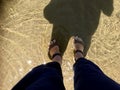 Female camino pilgrim cools her feet in a pool of sea water. Royalty Free Stock Photo