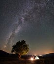 Woman resting at night camping in mountains under starry sky