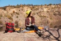 Female camper reading book while sitting on sleeping bag Royalty Free Stock Photo