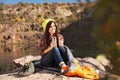 Female camper with thermos sitting on sleeping bag Royalty Free Stock Photo