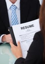 Female candidate holding resume at desk Royalty Free Stock Photo