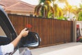 Female in car, hand using remote control to open the auto gate Royalty Free Stock Photo