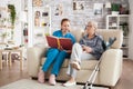 Female care giver reading a story from a book to a senior woman