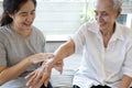 Female caregiver assisting to apply sunscreen lotion on the arms and body,skin care cream for elderly sensitive skin,happy smiling