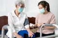 Female caregiver checking blood pressure measurement for the senior woman at home during the Covid-19 outbreak,asian elderly