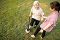 Female caregiver and healthy senior woman playing game the football outdoor at nursing home,relax exercise with old soccer ball,