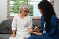 Female caregiver measuring glucose level of diabetic senior woman. Diabetes, healthcare concept