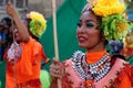 Female carnival dancer in ethnic costumes dances in delight along the road