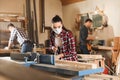 Female carpenter cleaning surface planer with air blow gun Royalty Free Stock Photo