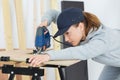 Female carpenter cutting wood with electrical jigsaw