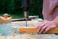 Female carpenter drilling wood plank, close-up view. Woodwork, DIY concept Royalty Free Stock Photo