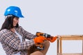 Female carpenter drills a hole with an electrical drill. Repair and renovation concept. Woman repair tools for house Royalty Free Stock Photo