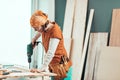 Female carpenter using electric drill