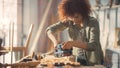 Female Carpenter Wearing Protective Safety Glasses and Using Electric Belt Sander to Work on a Wood Royalty Free Stock Photo