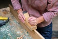 Female carpenter working with old wooden jointer plane, wood shaving concept Royalty Free Stock Photo