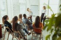 Female caucasian speaker giving presentation in hall at university or business centre workshop Royalty Free Stock Photo