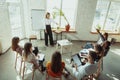 Female caucasian speaker giving presentation in hall at university or business centre workshop Royalty Free Stock Photo