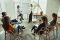 Female caucasian speaker giving presentation in hall at university or business centre workshop Royalty Free Stock Photo