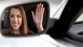 Female celebrity sitting in vehicle and waving hand, rearview mirror reflection