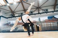 Female cheerleader in uniform doing a handstand in a sports hall. Royalty Free Stock Photo