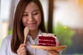 A female chef baking and eating a piece of red velvet cake in wooden tray Royalty Free Stock Photo