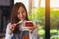 A female chef baking and eating a piece of red velvet cake in wooden tray Royalty Free Stock Photo