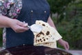 Female chef, coock wearing apron, holding pita, taco, shawurma, frying, baking outdoor. Royalty Free Stock Photo