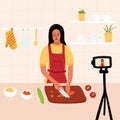 Female chef cooking in the kitchen while recording video using her camera for her online video channel. Cook healthy food at home