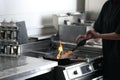 Female chef cooking meat with manual gas burner on stove in restaurant kitchen, closeup Royalty Free Stock Photo