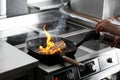 Female chef cooking meat with manual gas burner on stove in restaurant kitchen Royalty Free Stock Photo