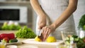 Female chef cutting lemon with sharp knife for lunch preparing, cooking tips Royalty Free Stock Photo