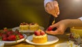 Female chef decorating cakes with fruits on the table