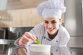 Female chef garnishing dish Royalty Free Stock Photo