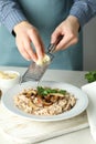 Female chef grate cheese on risotto with mushrooms Royalty Free Stock Photo
