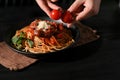 Female or chef hands putting some fresh tomato on a plate of spaghetti Royalty Free Stock Photo