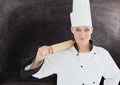 Female chef holding rolling pin against black background Royalty Free Stock Photo