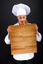 Female chef holding a wooden boards
