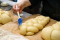 Female chef lubricate the bakery products with an egg yolk. Cook