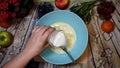 Female chef pouring milk in a bowl, pancake preparation, top view