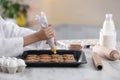 Female chef preparing biscuits at kitchen table. Cooking delicious food