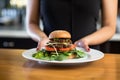 female chef presenting a black bean burger on a plate