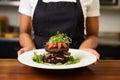 female chef presenting a black bean burger on a plate